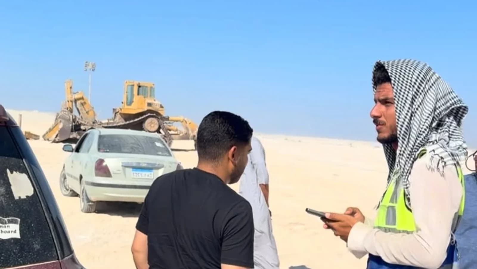 فريق ميداني ومعدات إنشاء في موقع مشروع بمنطقة صحراوية